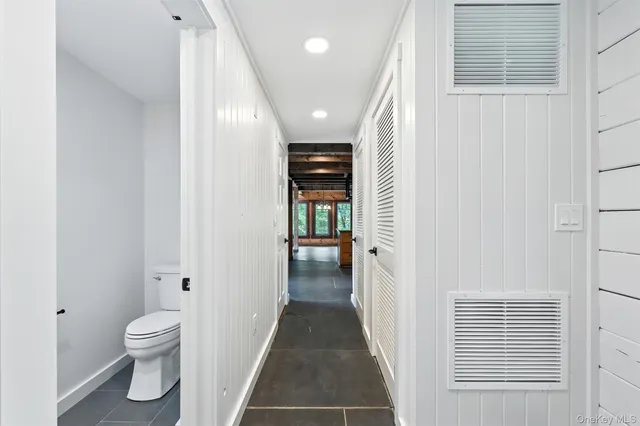 a view of a hallway of bathroom with a toilet