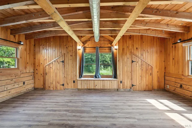 a view of a room with wooden floor and windows