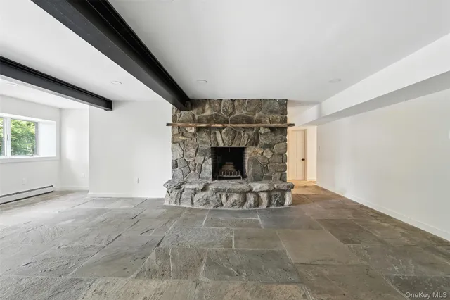 a view of an empty room with a fireplace and window