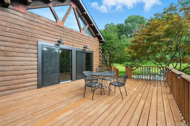 a balcony with wooden floor table and chairs