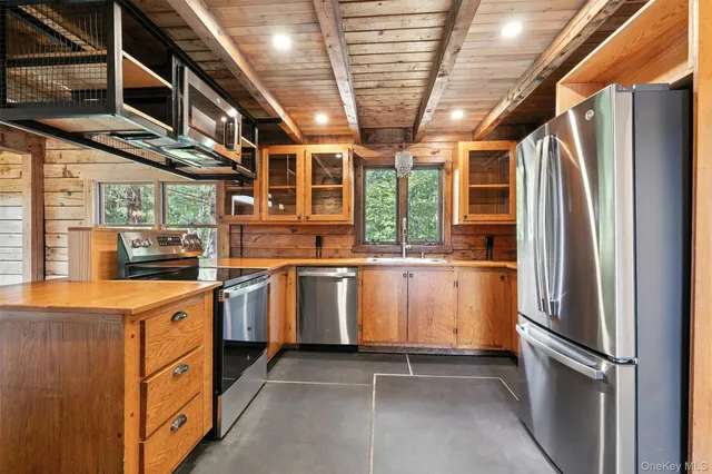 a kitchen that has a lot of cabinets in it and stainless steel appliances