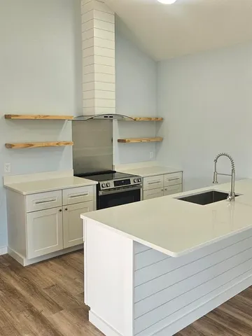 a kitchen with white cabinets appliances and sink
