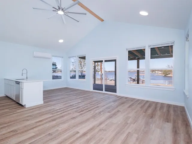 a view of an empty room with window and wooden floor