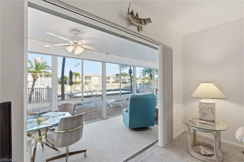 a living room with furniture a chandelier and a large window