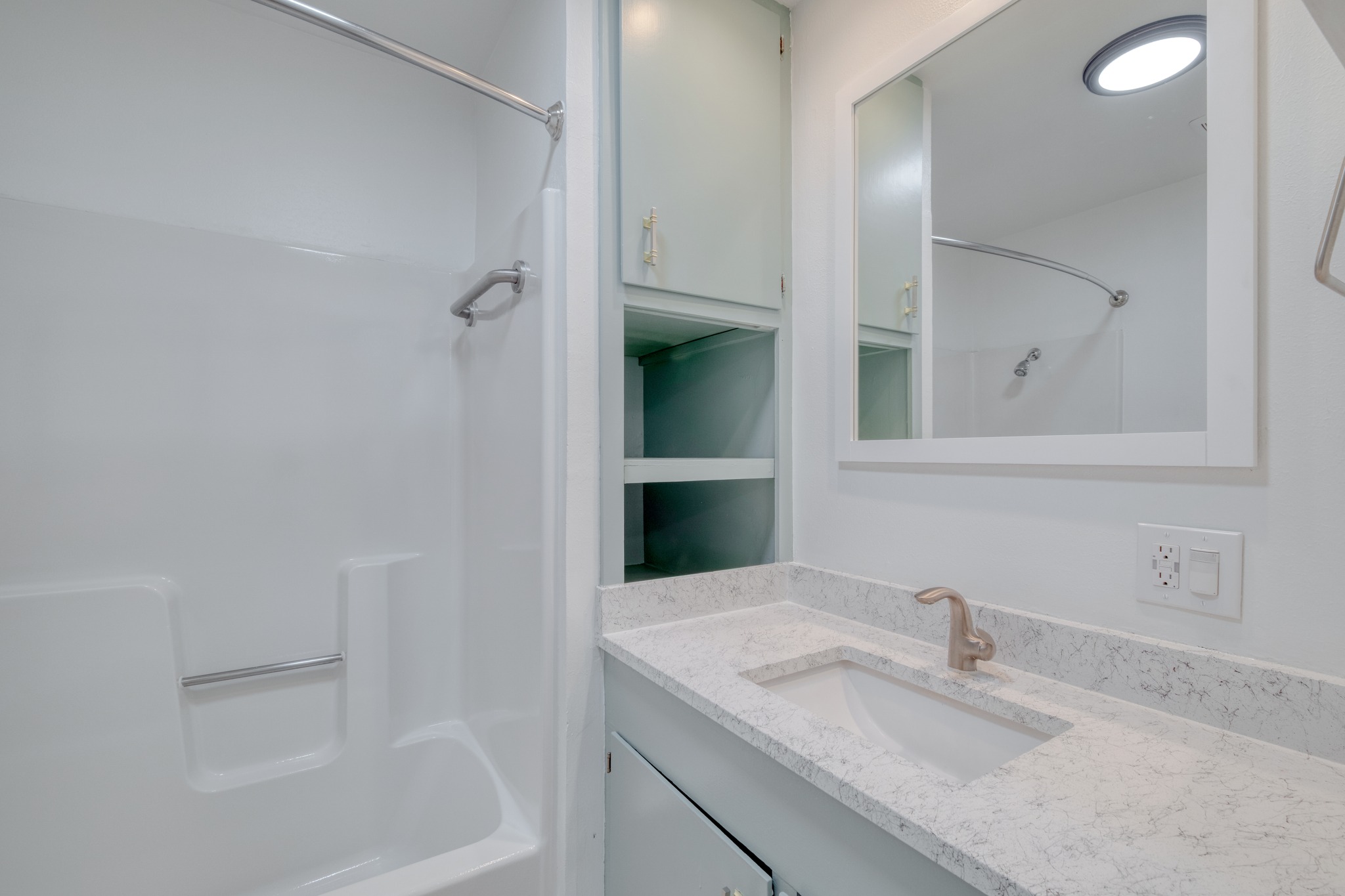 20960 Cameron Road Coupland, TX 78615 - Photo 14 of 21 An integrated tub and shower unit neighbors a sleek vanity topped with durable stone counters.