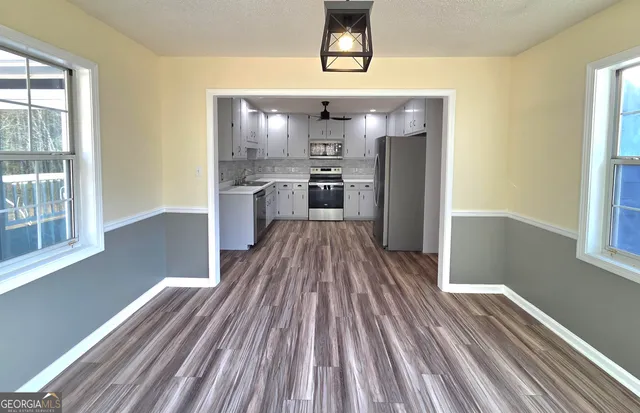 a kitchen with a sink cabinets stainless steel appliances and a window