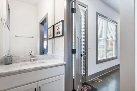 a bathroom with a granite countertop sink and a mirror