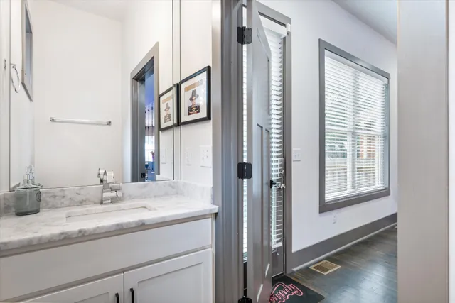 a bathroom with a granite countertop sink and a mirror
