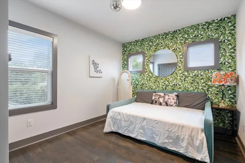 a bedroom with a bed lamp and a potted plant