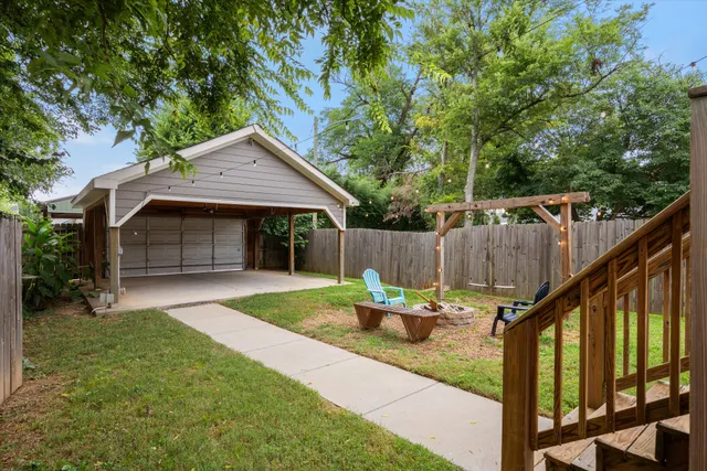 a backyard of a house with table and chairs