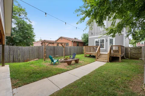 a view of a backyard with couches plants and large tree
