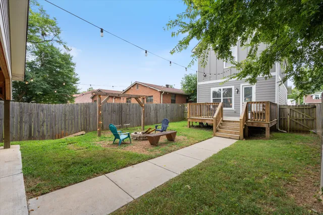 a view of a backyard with couches plants and large tree