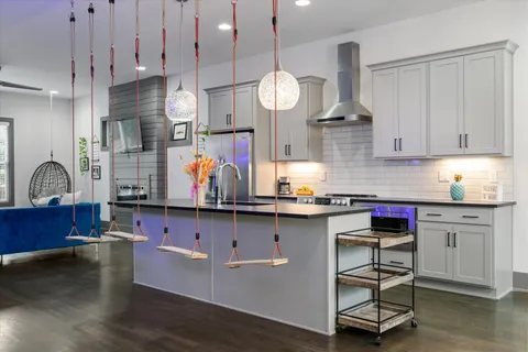 a kitchen with granite countertop a stove a sink and a wooden cabinets