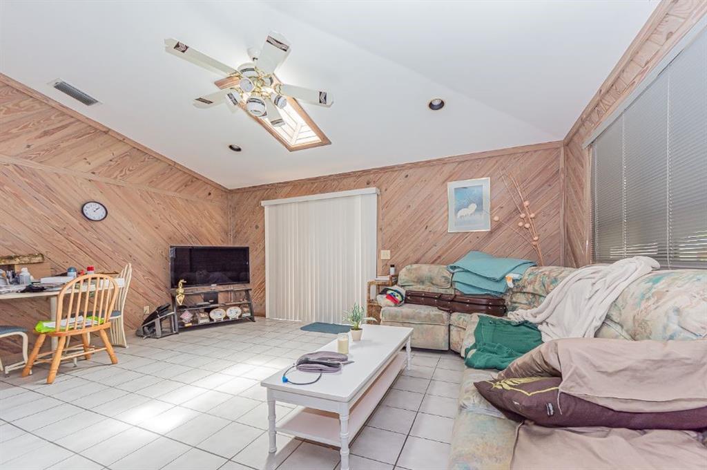 670 Cypress Road Vero Beach, FL 32963 - Photo 11 of 20 a living room with furniture a flat screen tv and a window