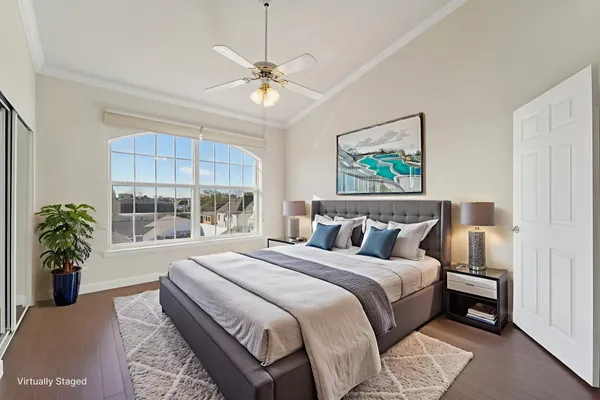 a bedroom with a large bed a potted plant and a dresser