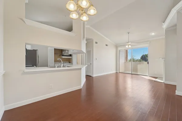 a view of an empty room with a kitchen and kitchen view