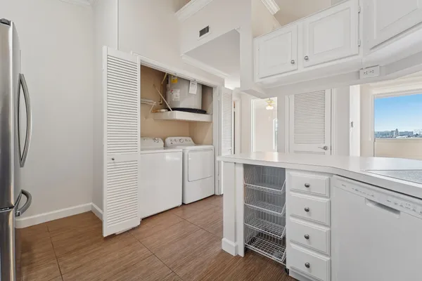 a living room with stainless steel appliances kitchen island a sink a stove and white cabinets
