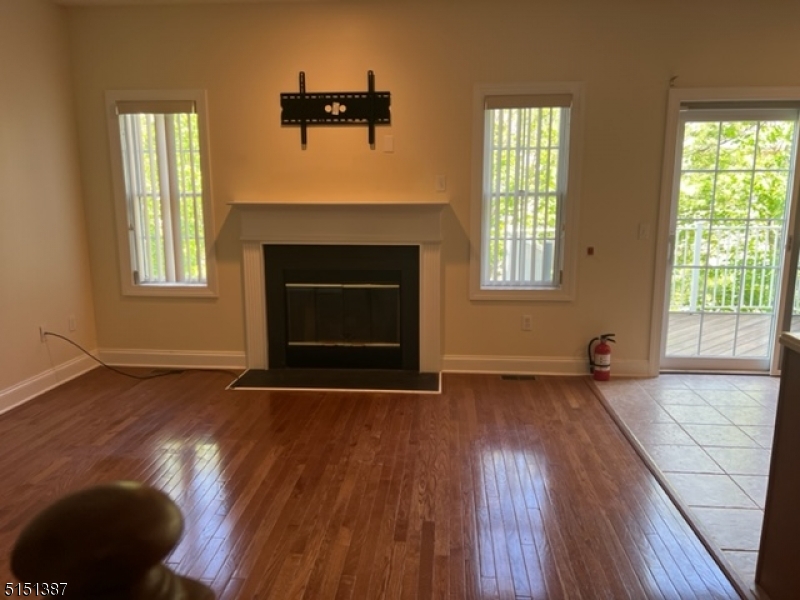 a view of a livingroom with wooden floor and a fireplace