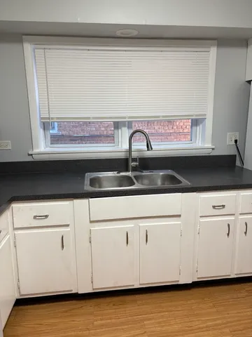 a kitchen with a refrigerator and white cabinets