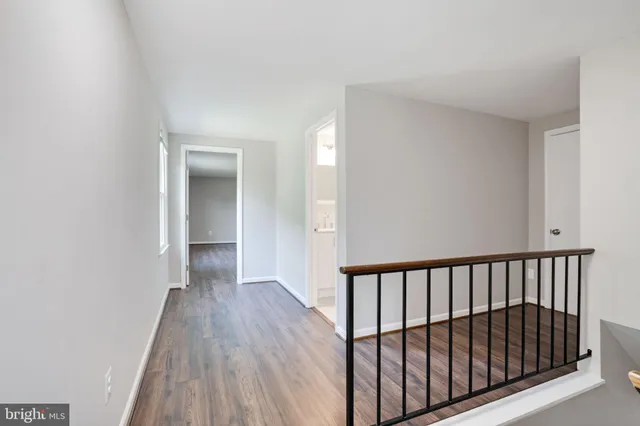 a view of a white house with a big yard and large trees