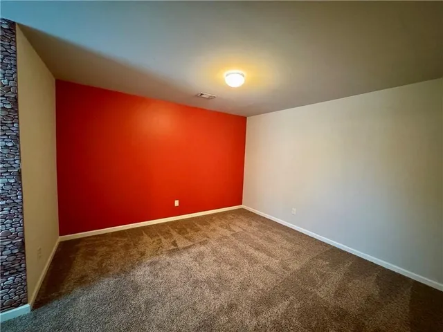 an empty room with yellow carpet