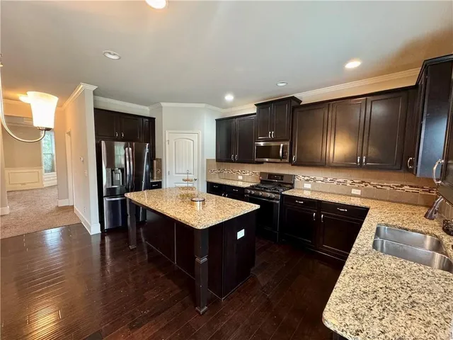 a kitchen with stainless steel appliances granite countertop a sink stove and refrigerator
