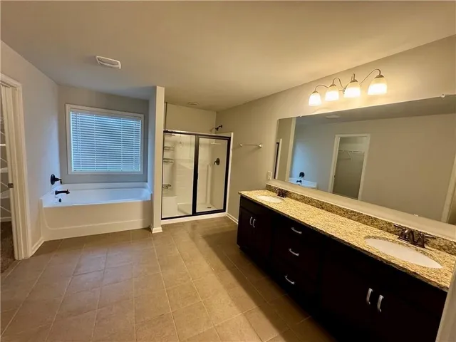 a spacious bathroom with a tub sink and mirror