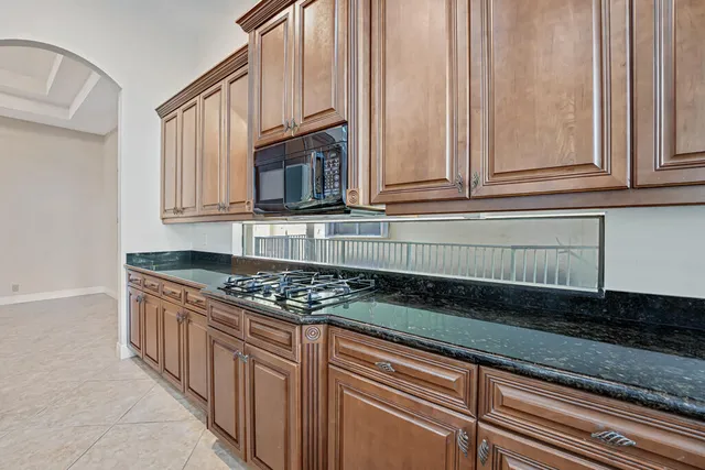 a bathroom with a granite countertop sink a toilet and a mirror