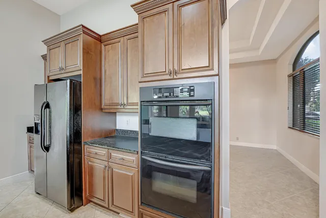 an empty room with wooden floor chandelier fan and windows