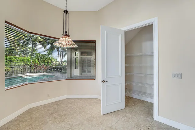 an empty room with closet and a chandelier fan
