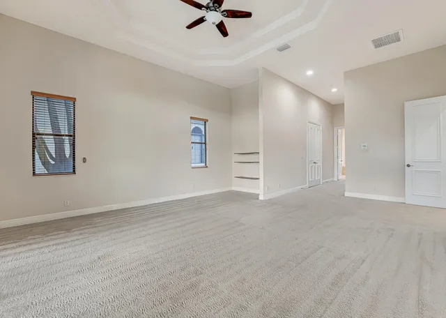 a front view of a house with a yard and potted plants
