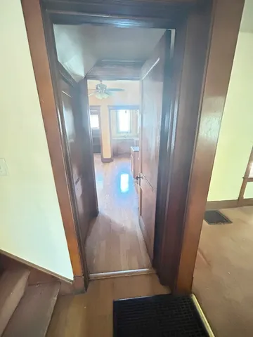 a view of a hallway with wooden floor and a dining room
