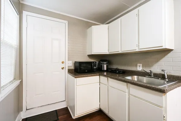 a kitchen with granite countertop a sink and cabinets
