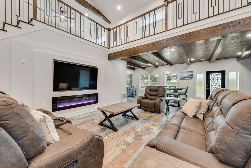 11167 Plainview Road Krum, TX 76249 - Photo 11 of 40 Two-story living area featuring a built-in electric fireplace and decorative wood-finish ceiling beams