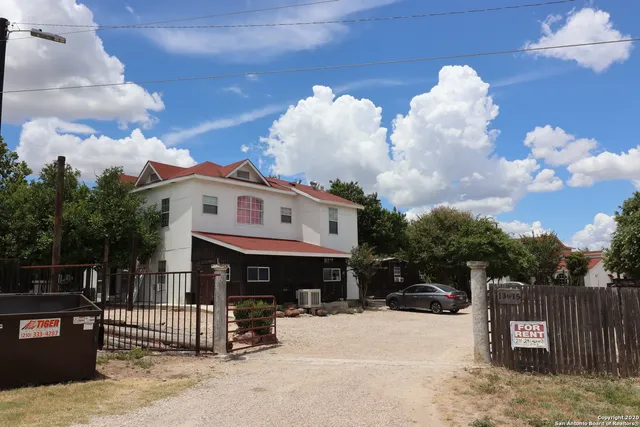 a front view of a house with a large tree