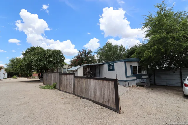 a view of a house with a backyard and a tree