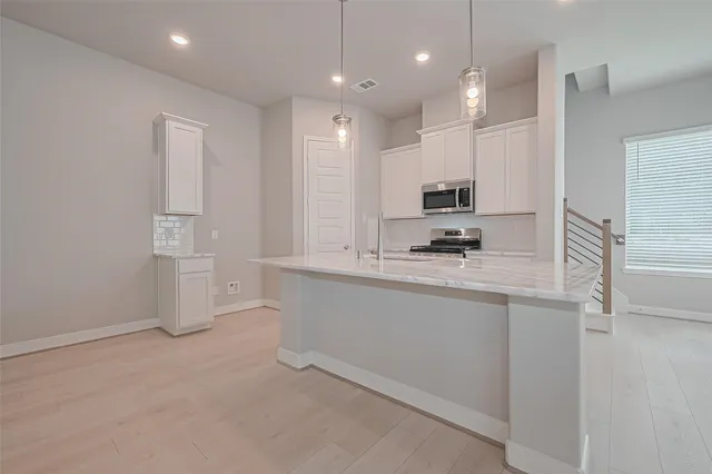 a kitchen with stainless steel appliances granite countertop a refrigerator and a stove top oven