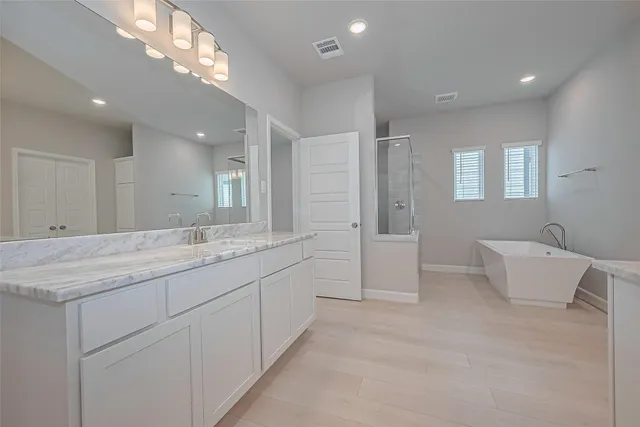 a bathroom with a granite countertop sink a mirror and a shower