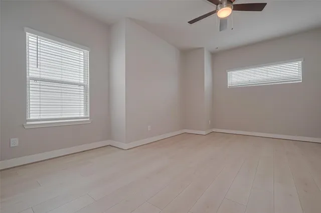 an empty room with a chandelier fan
