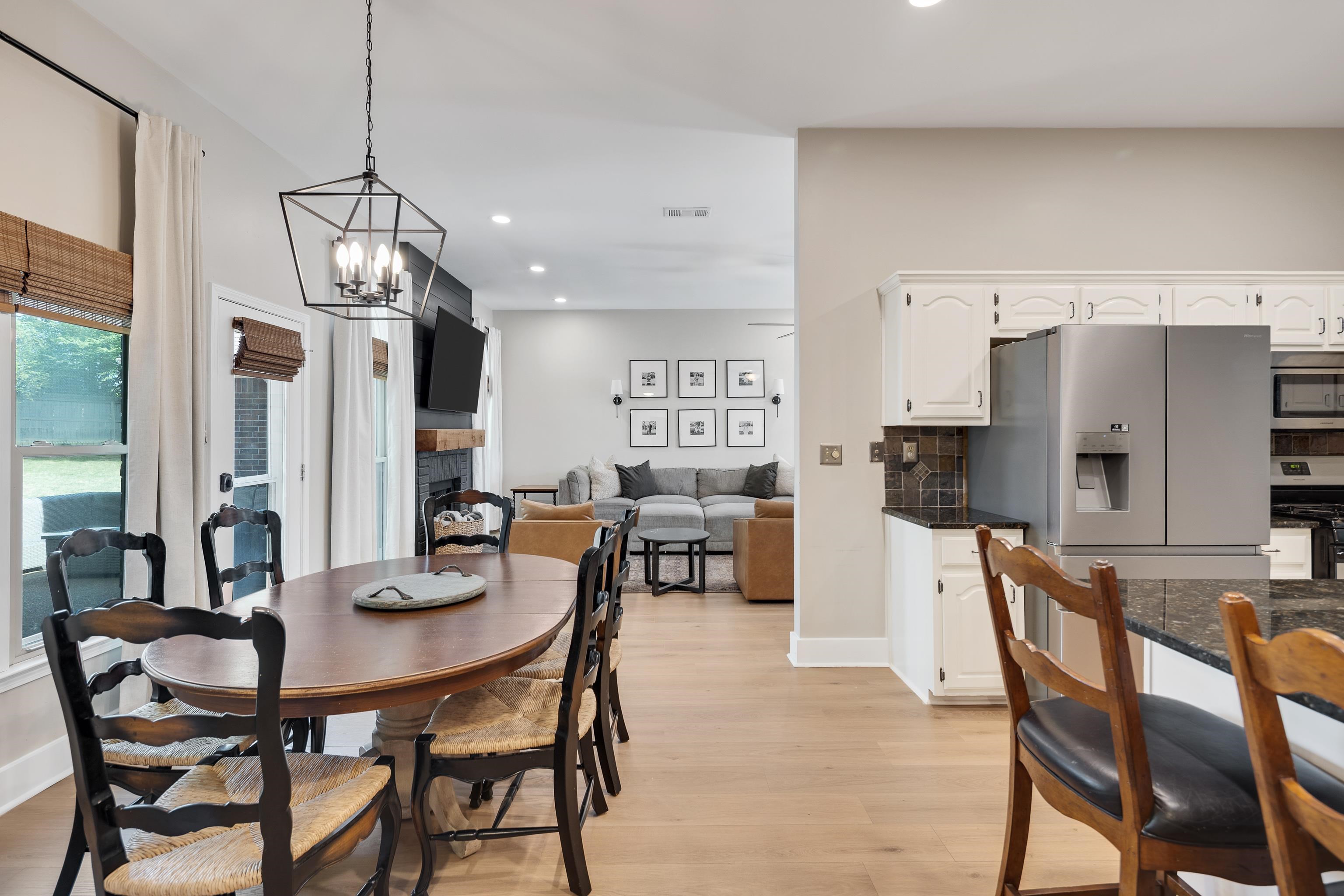 288 Hughes Cove Collierville, TN 38017 - Photo 13 of 31 Dining room with light wood-style floors, suspended lighting, and a brick fireplace