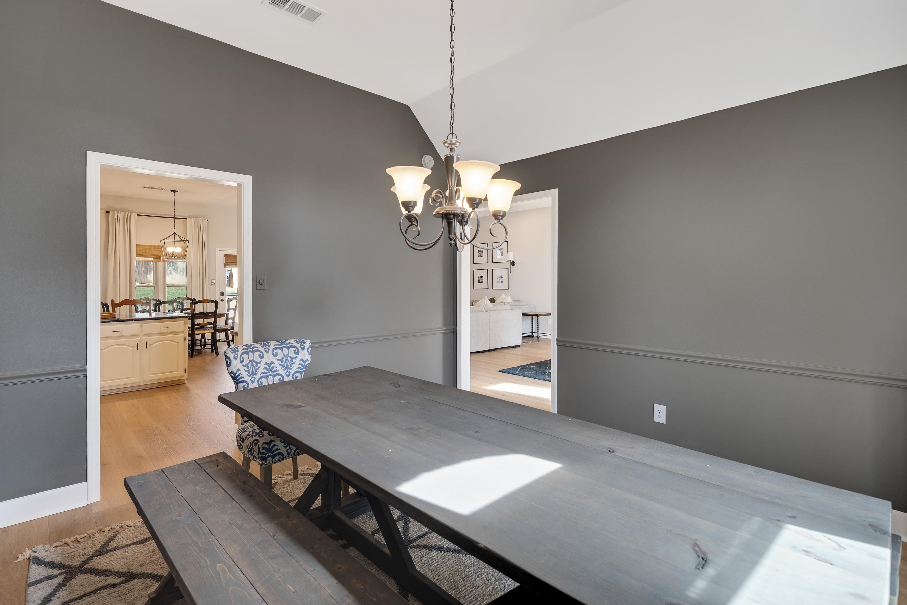 288 Hughes Cove Collierville, TN 38017 - Photo 14 of 31 Dining room featuring vaulted ceiling, light wood-style floors, and suspended lighting