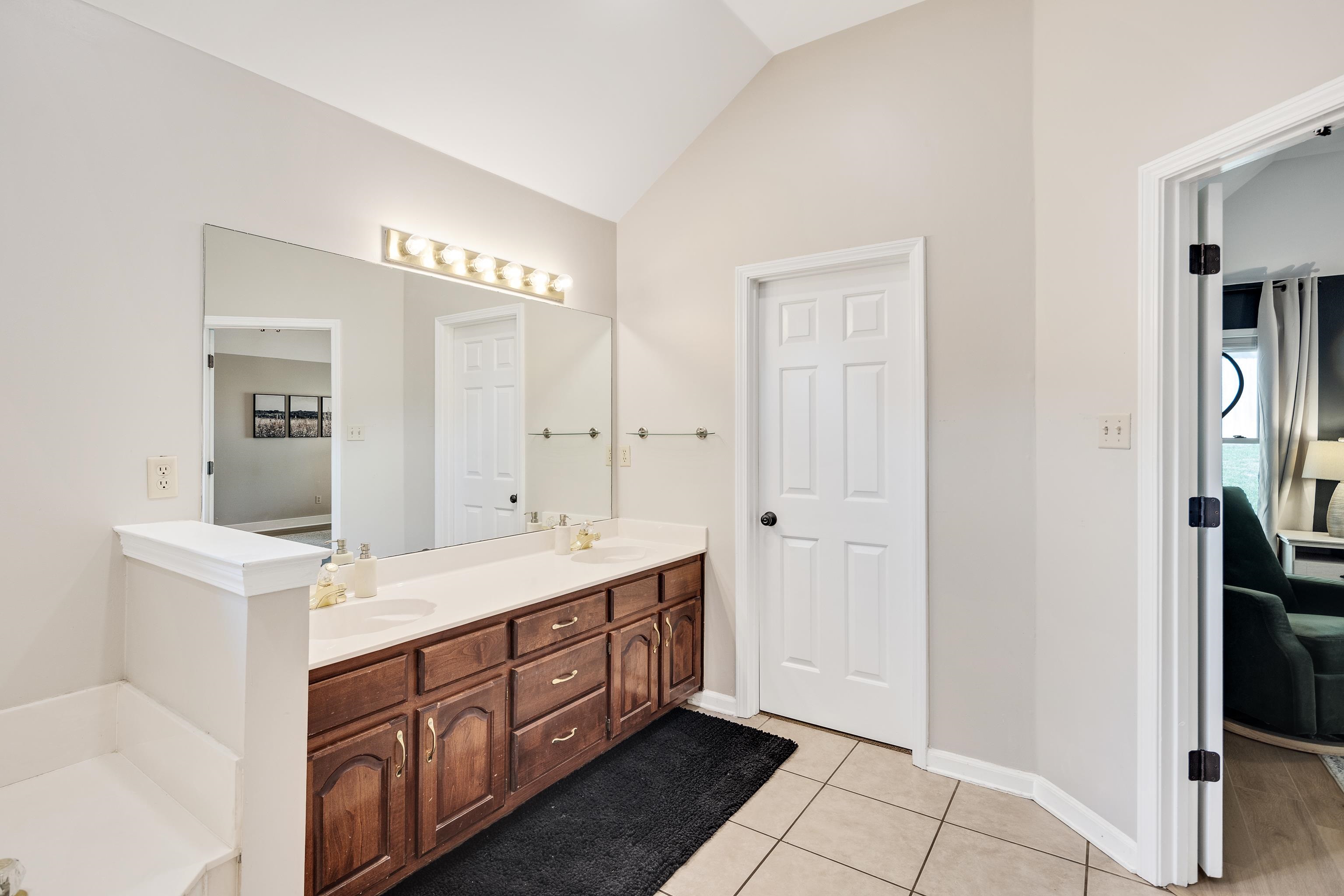 288 Hughes Cove Collierville, TN 38017 - Photo 18 of 31 Bathroom with double vanity, lofted ceiling, and light tile patterned floors