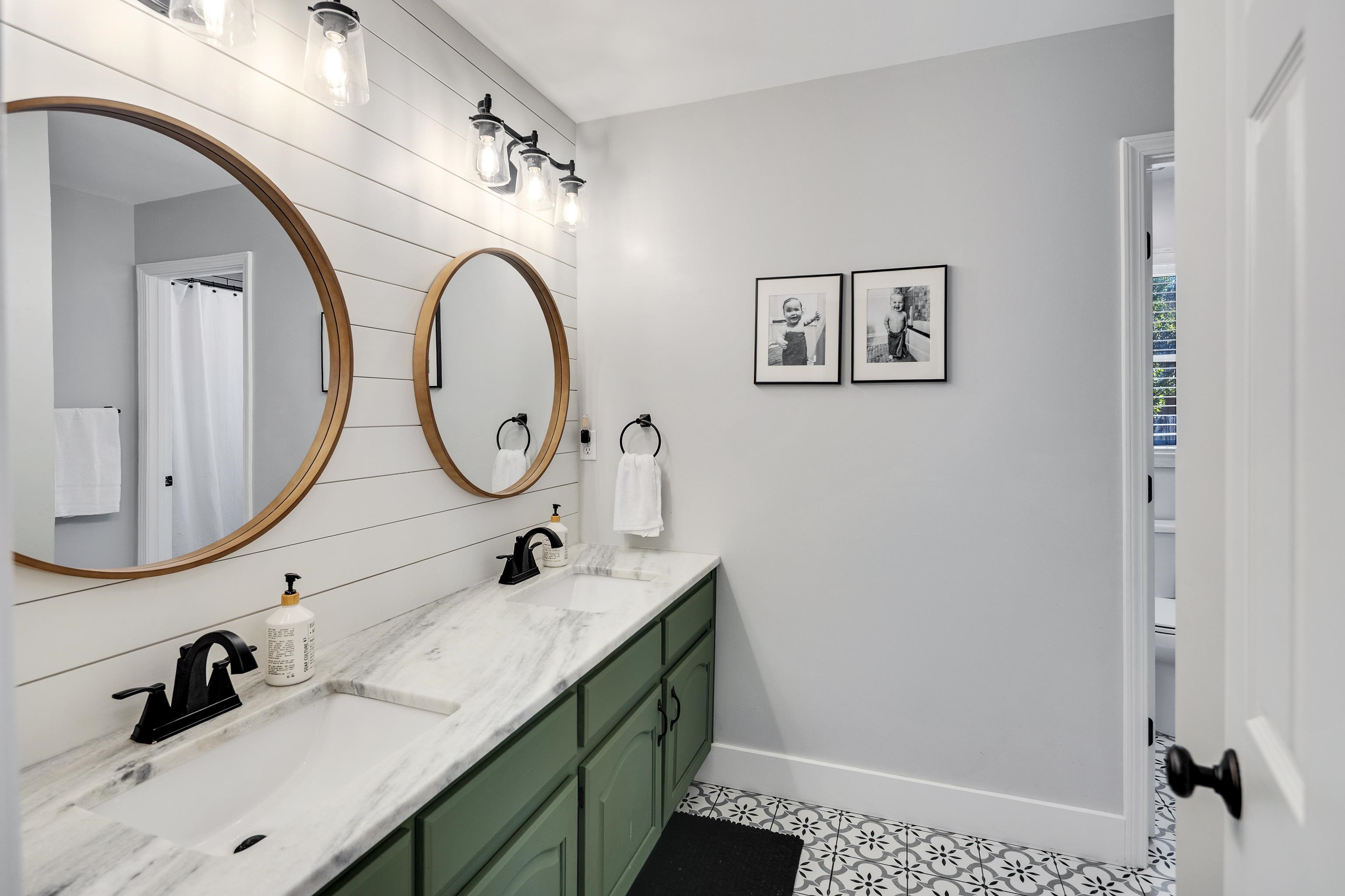 288 Hughes Cove Collierville, TN 38017 - Photo 22 of 31 Full bathroom featuring double vanity, a shower with shower curtain, light tile patterned flooring, and wooden walls