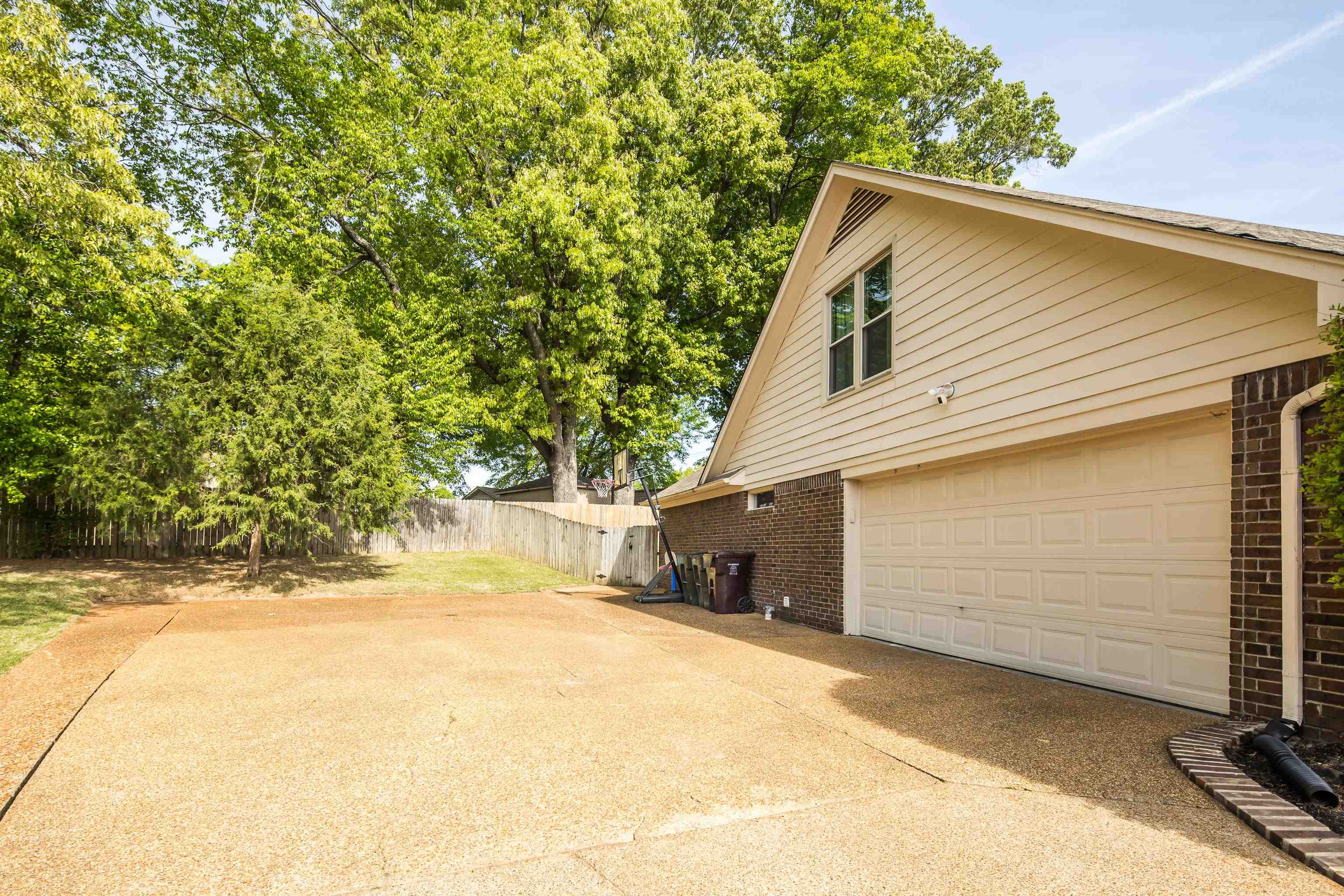 288 Hughes Cove Collierville, TN 38017 - Photo 27 of 31 View of property exterior featuring brick siding, a garage, and driveway