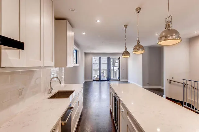 a kitchen with stainless steel appliances granite countertop a sink a stove and a wooden floors