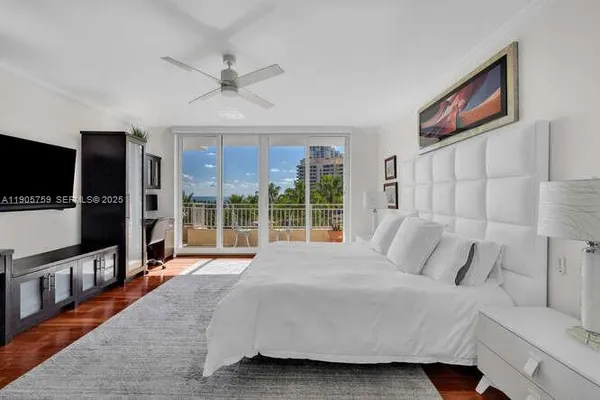 a bedroom with a large bed and a flat tv screen on dresser