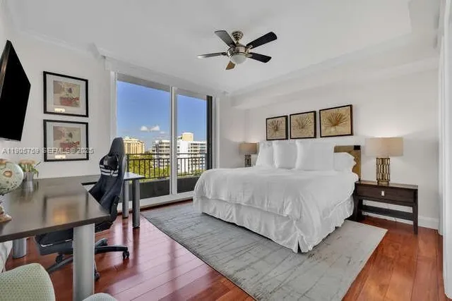 a bedroom with a bed a desk and chair with the wooden floor