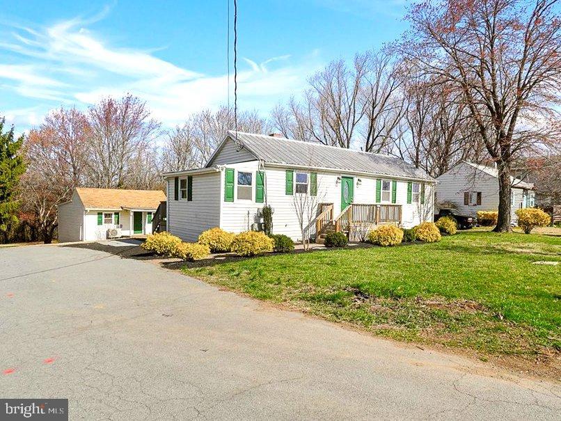 a view of a house with a yard and street
