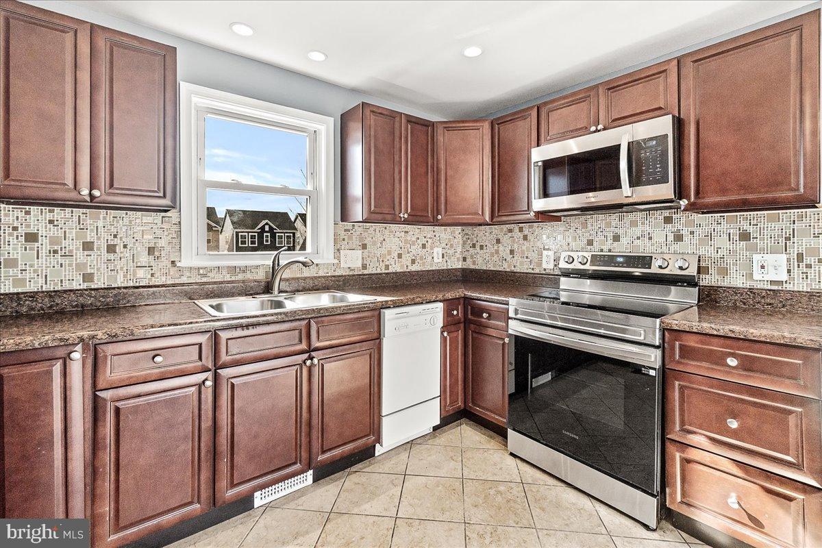 22310 Clarksburg Road Boyds, MD 20841 - Photo 13 of 47 a kitchen with stainless steel appliances granite countertop a sink stove and microwave