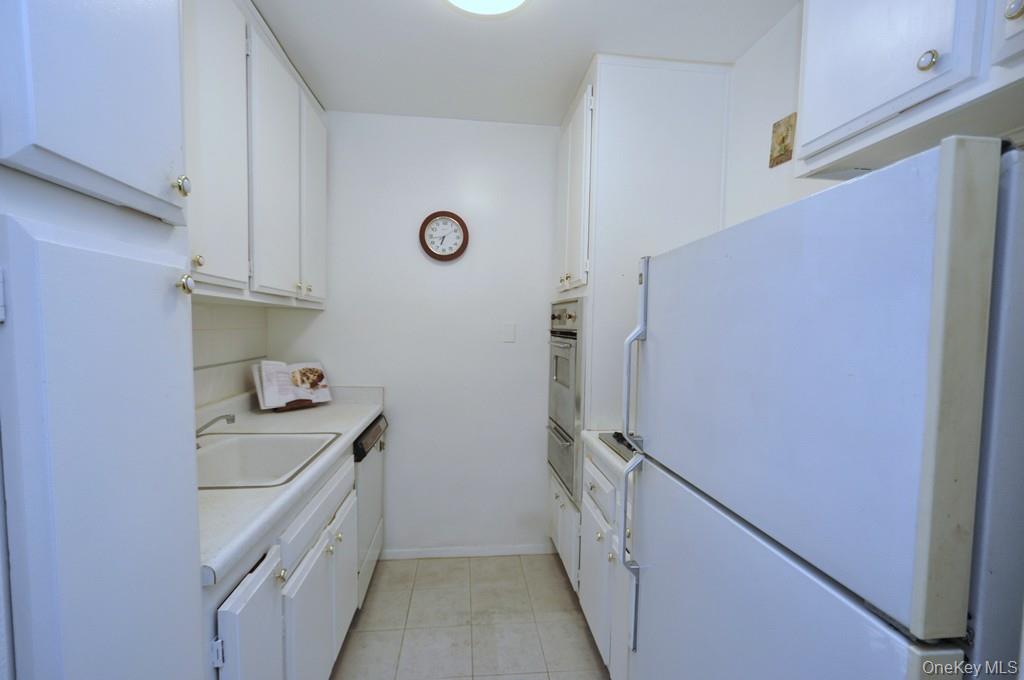 260 Garth Road, Unit 4A5 Scarsdale, NY 10583 - Photo 11 of 35 a kitchen with a sink and a refrigerator